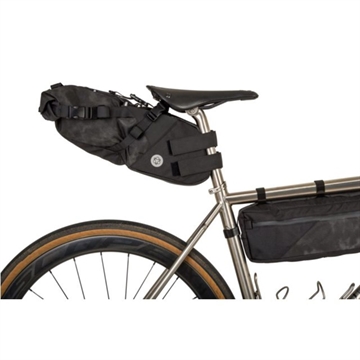Sort sadeltaske monteret på cykelsadelstang, med cykelstel og baghjul synlige.